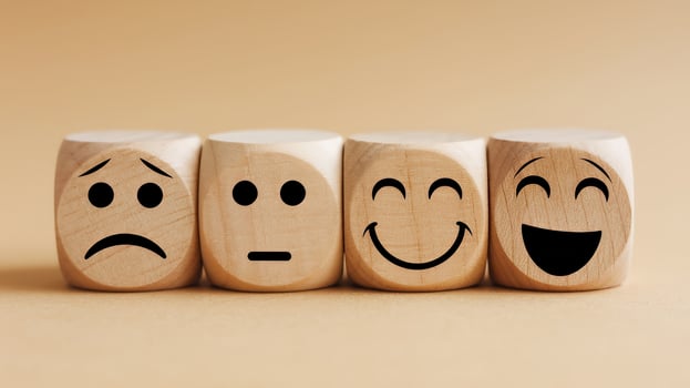 Wooden blocks displaying a range of emotions from sadness to joy illustrating the spectrum of human photo