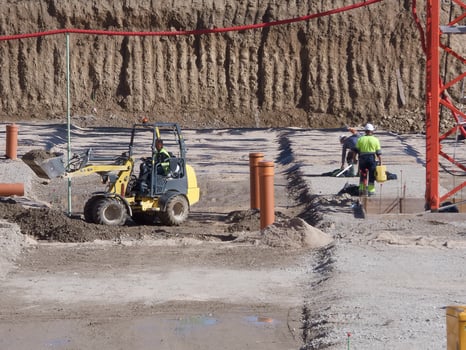 Construction site activity featuring machinery and workers at a development project in sunny conditions photo