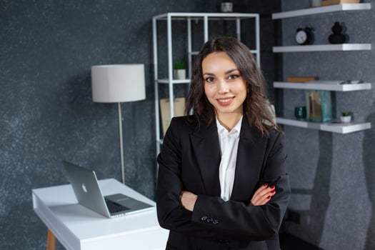 portrait of smiling businesswoman with crossed arms looking at camera in office. photo