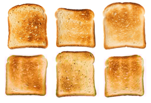Variations of perfectly toasted bread slices arranged symmetrically on a white background showcasing different shades of golden brown crust photo