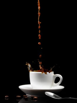 Pouring coffee into a white cup with splashes photo
