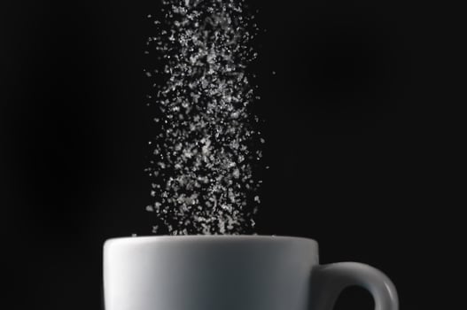 Pouring sugar into a cup photo