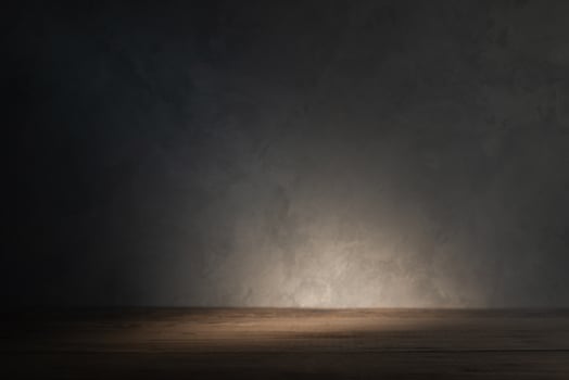 Table top on concrete wall background with beam of light photo