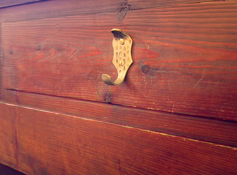 Rustic wooden wall with vintage metal hook in warm lighting photo