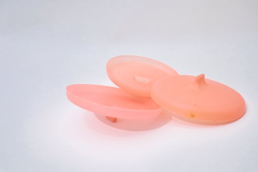 Peach Plastic Discs Isolated On White Backdrop In A Minimalist Style photo