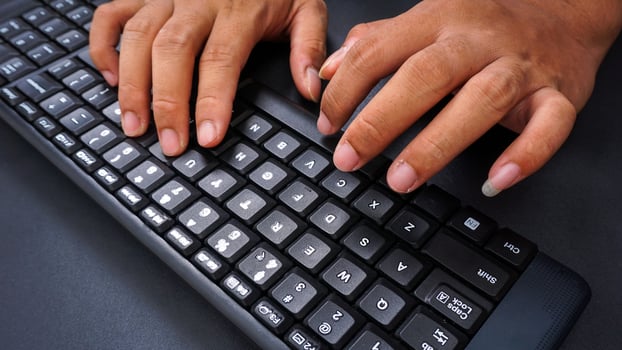 Finger texting on keyboard isolated on black background photo