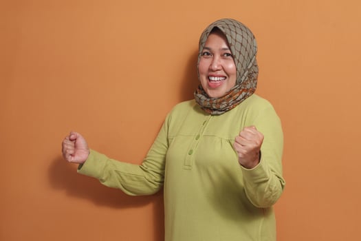 Cheerful Muslim woman shows victory joy and confidence expression photo
