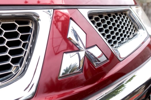 Riau, Indonesia, 2025 - Mitsubishi logo emblem on the front of the red car photo