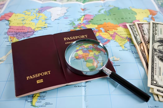 Magnifying glass showing africa on world map with passport and us dollars photo