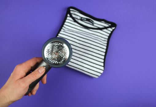A woman's hand is about to clean lint from clothes. photo