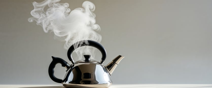 Steam coming out of a kettle on a table photo