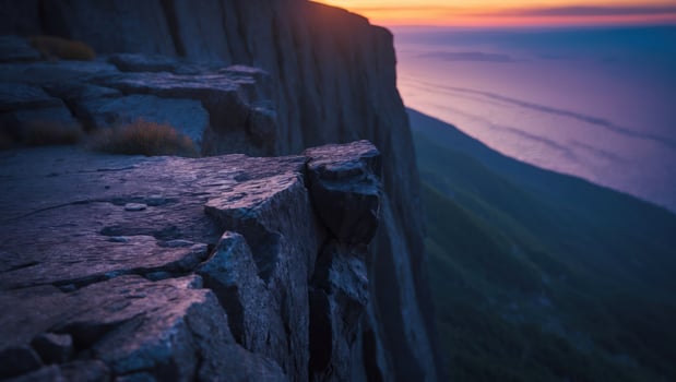 Cliff Edge Overlooking Ocean at Sunset with Purple and Orange Hues photo