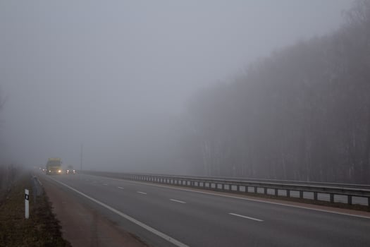 Fog on the road. Poor visibility on the highway. Cars on the motorway. photo