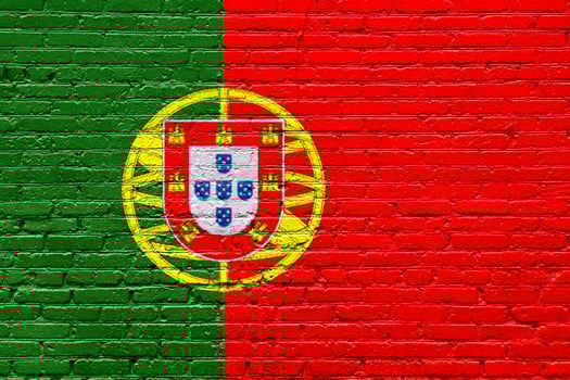 Portugal flags on a textured brick wall with grunge and graffiti details photo