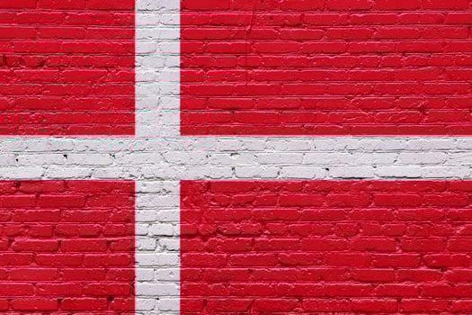 A collection of European national flags including Denmark, displayed on a textured brick wall with a patriotic and grunge aesthetic photo