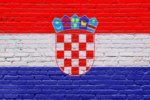 croatia flag painted on a wooden tag with a patriotic, grunge texture on a brick wall photo