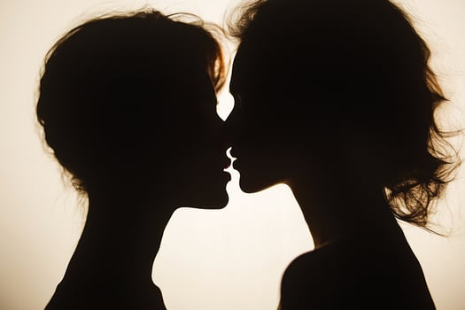 Romantic Silhouettes of Two Individuals Sharing a Tender Moment Against a Soft Light Background photo