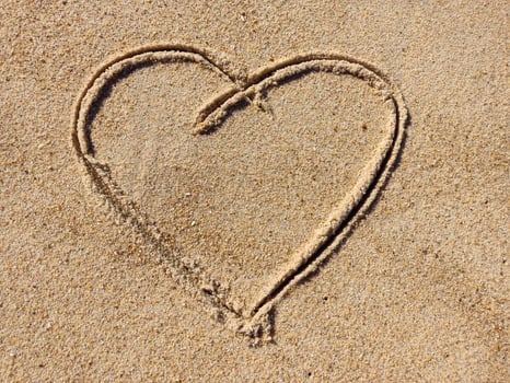 Heart drawn in the sand on the beach photo