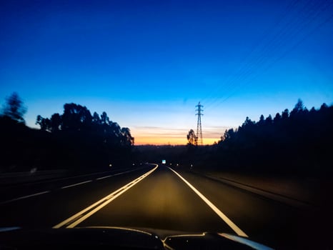A car driving down a road at dusk photo