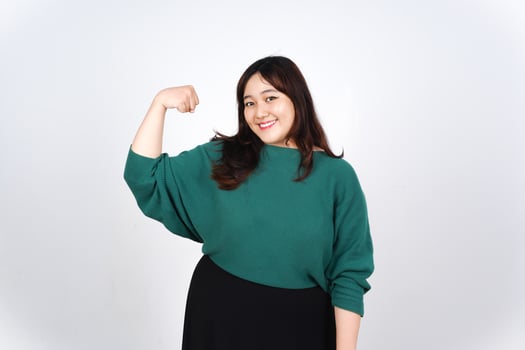 A woman in a green sweater flexing her arm photo