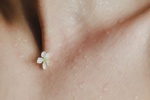 Close up cherry blossom flower on a dew female skin with water drops. Concept for purity, freshness and clean skin. photo