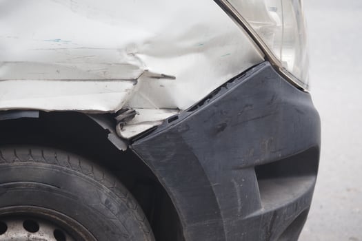 Car damage on a city street after a minor collision photo