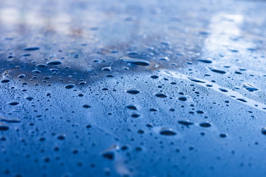 Water droplets accumulate on a blue surface after rainfall during the early morning hours photo