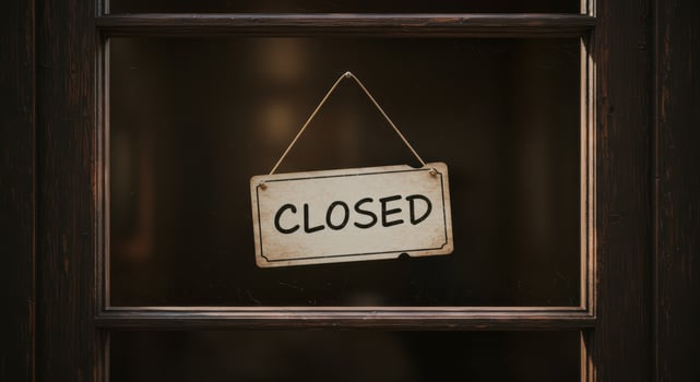 CLOSED sign hangs in the window of a wooden framed door. photo