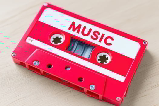 Red music cassette tape lying on wooden table photo