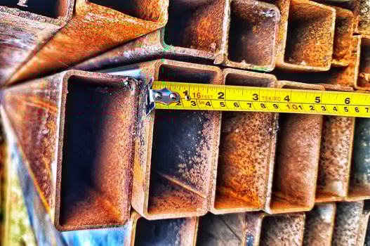 Measuring Rusty Metal Square Tubing with Tape Measure for the Construction photo