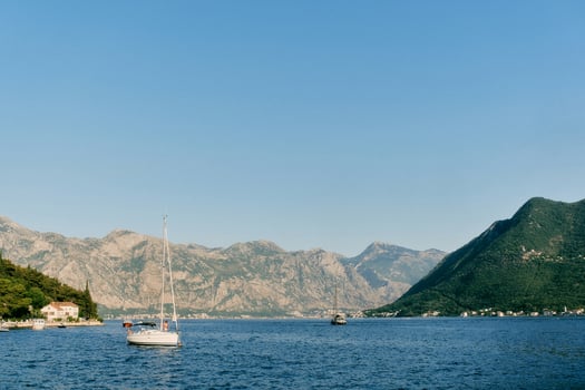 Small sailing yacht is moored in the sea near the coast of Perast. Montenegro photo