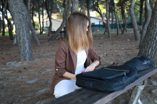 Opens Case Of Bass Musical Instrument On Table In Park Among Trees photo