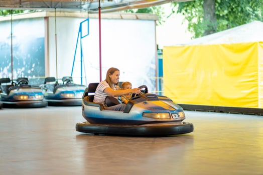 Mother and son having ride in the bumper car at the amusement park photo