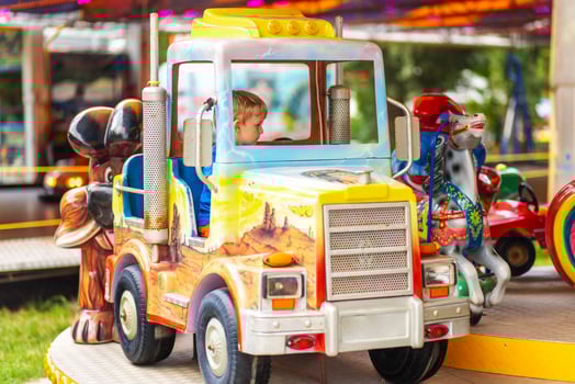 Little boy enjoying his rides at the carousel in the amusement park photo