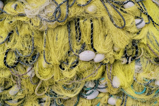 Yellow fishing net with black ropes and white floats. Top view photo