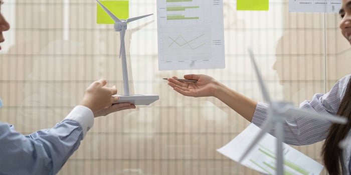 Renewable Energy Collaboration. Professionals discussing wind energy projects and sustainability metrics in a corporate environment. photo