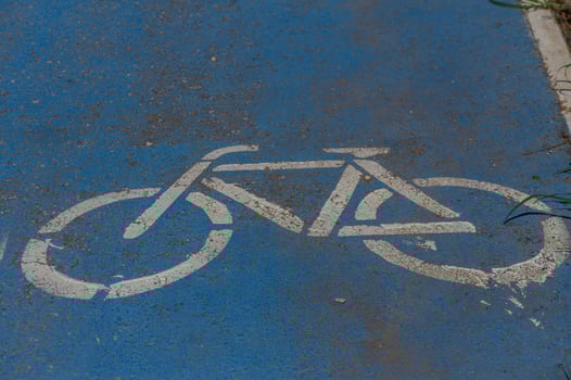 Bicycle symbol painted on a vibrant blue path signifies a welcoming space for cyclists in the city photo