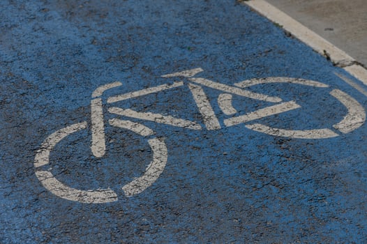Bicycle lane marking on a vibrant blue pavement indicating safe space for cyclists in an urban setting photo
