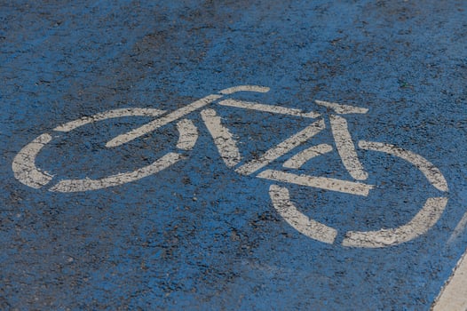 Bicycle symbol painted on a vibrant blue pavement in an urban setting promoting cycling for all photo