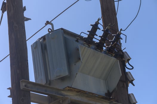 Electric transformation station high above, serving power to the bustling neighborhood below in bright daylight and clear skies photo