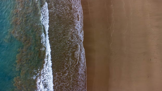 Aerial View of Waves Crashing on Sandy Beach, Beautiful Beach at Lenggoksono Beach photo