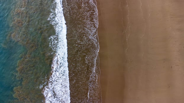 Aerial View of Beautiful Waves Crashing on Sandy Beach at Lenggoksono Beach photo