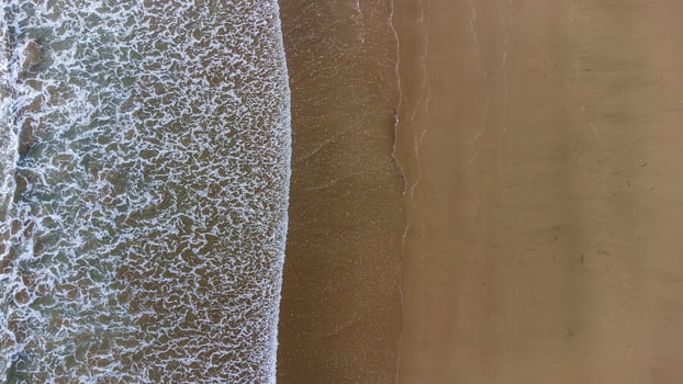 Aerial View of Waves Crashing on Sandy Beach at Lenggoksono Beach photo