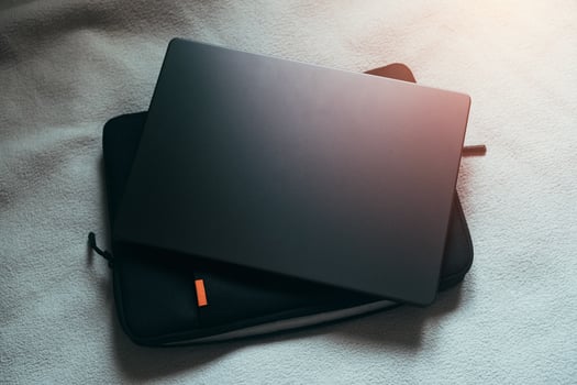 Background image of white bed with laptop and case. Work from home. Nomad life concept. photo