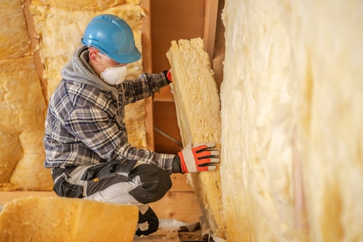 Construction Worker Insulating a Wall at a Building Site photo
