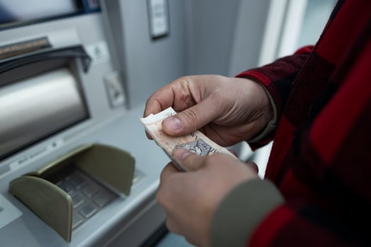 ATM Cash Withdrawal in Zloty, Man Taking Money from Cash Machine photo
