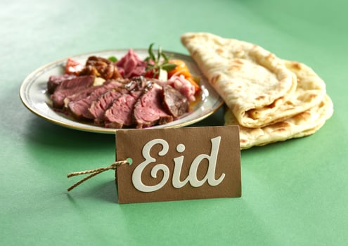 Eid islamic holiday concept with meat and pita bread on green background photo
