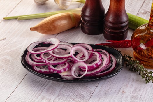 A bowl of onions and other ingredients on a table photo