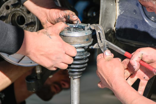 car repair tools and hands working, mechanics working on car suspension closeup photo