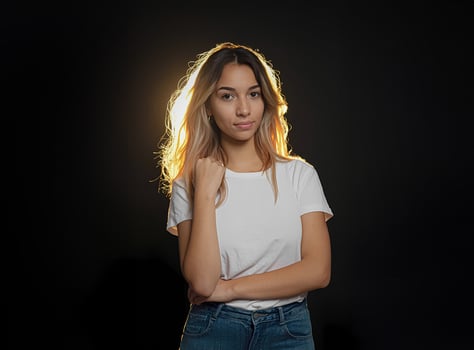 Beautiful blonde woman in white shirt on black background with light photo